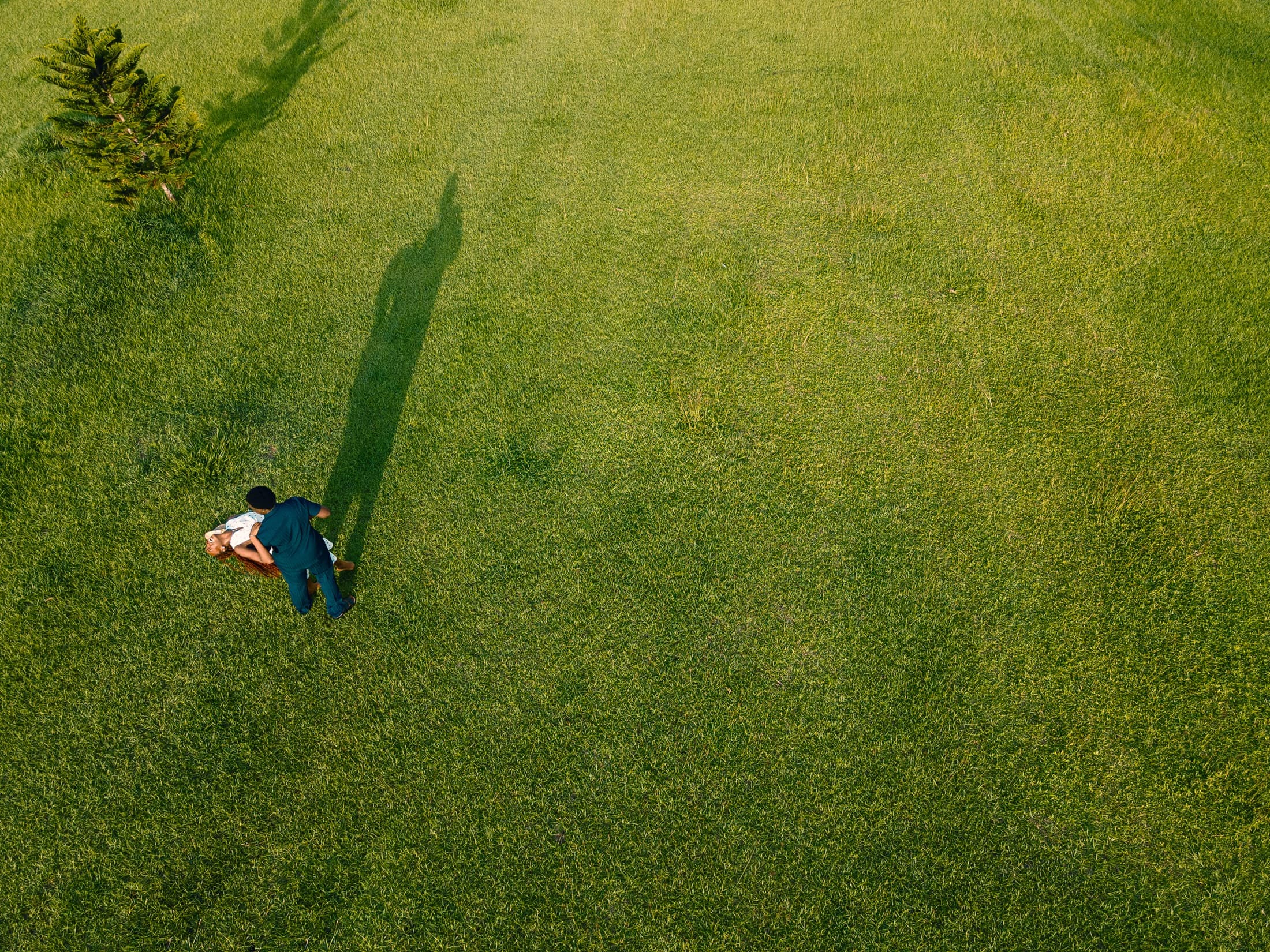 A wide aerial portrait of Esther-Praise and Jeremiah in a field